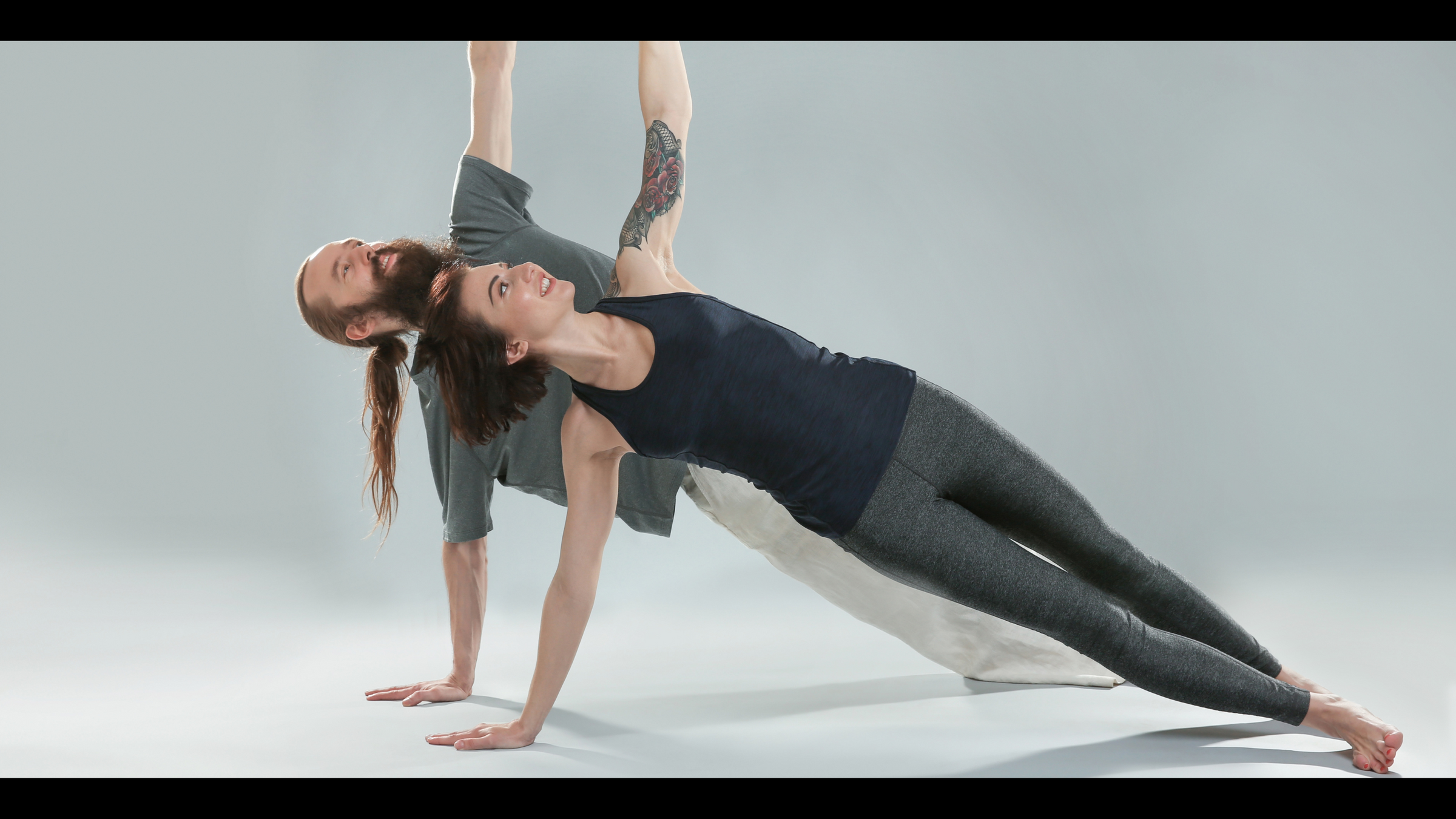 man and woman in side plank yoga pose